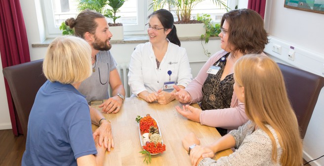 Prof. Dr. Karin Oechsle (M.) und Soziologin Anneke Ullrich (2. v. r.) im Angehörigengespräch. Auf der Palliativstation untersucht ihr Team die psychischen Belastungen von Angehörigen