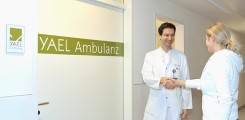 Arzt und Patientin begrüßen sich vor der Yael-Ambulanz